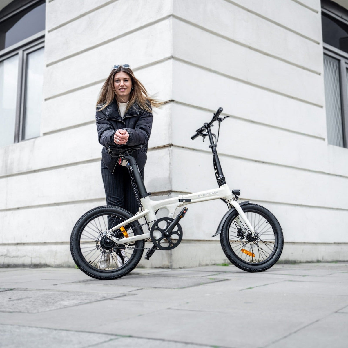 Mujer junto a una bicicleta eléctrica plegable ADO en la ciudad