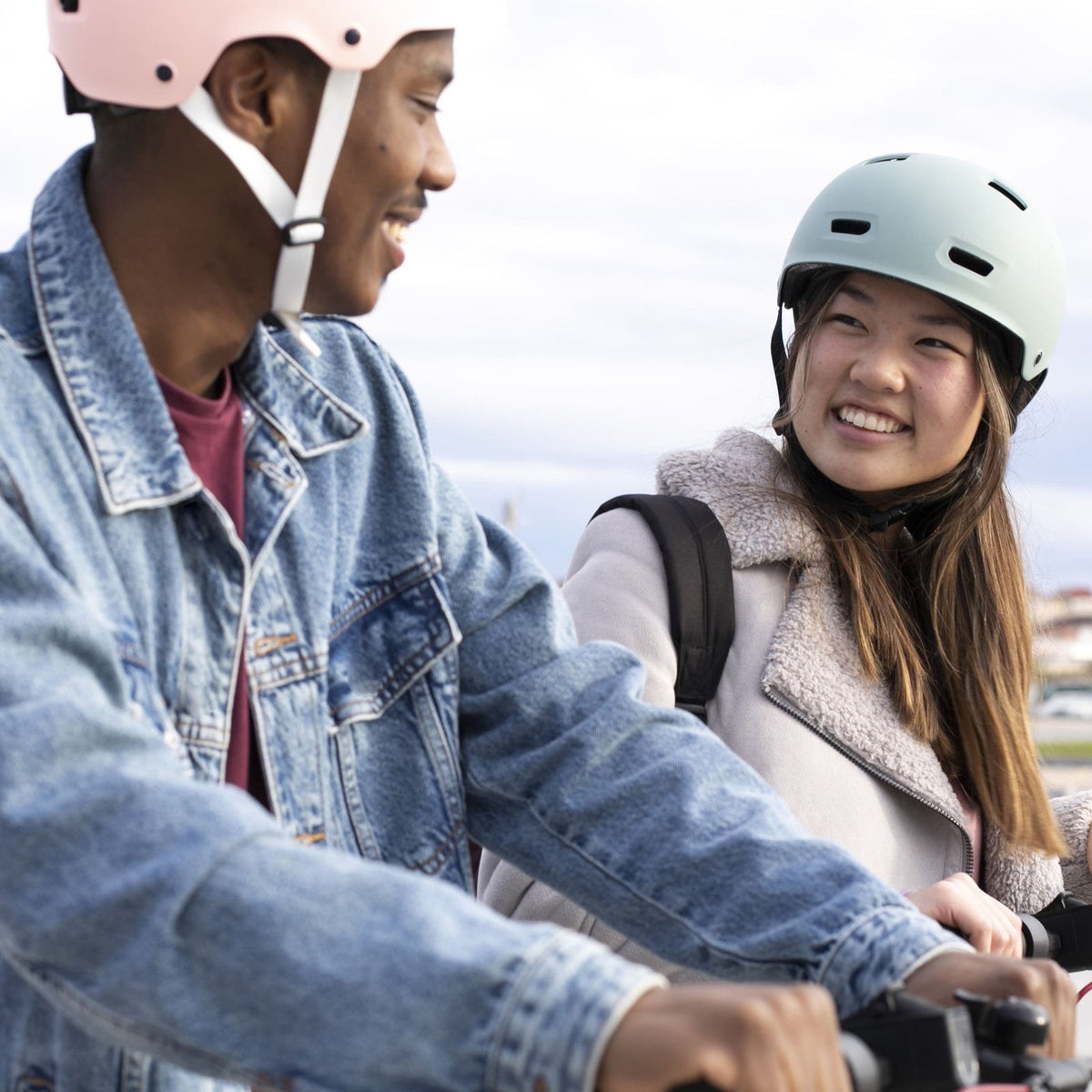 Pareja con cascos urbanos E-Mobility sobre sus bicicletas