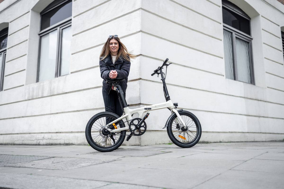 Mujer junto a una bicicleta eléctrica plegable ADO A20 Air