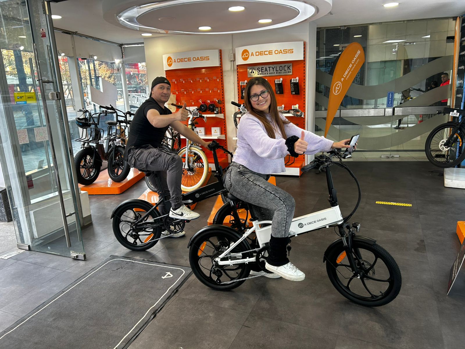 Clientes sobre bicicletas eléctricas ADO en el showroom de E-Mobility