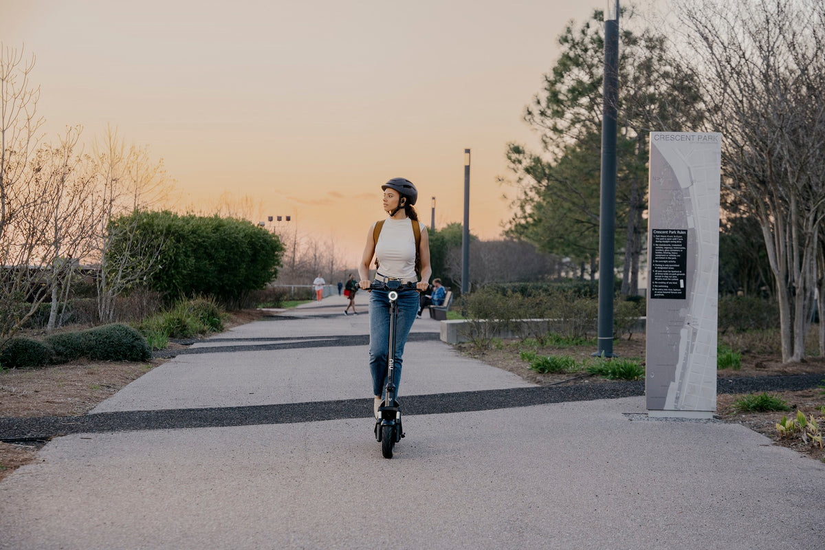 Mujer en scooter eléctrico NIU al atardecer