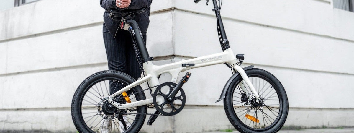 Bicicleta eléctrica plegable ADO apoyada en una fachada urbana - E-Mobility Chile