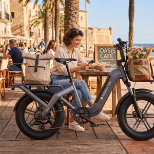 Mujer en la terraza de un café junto al mar con una Bicicleta Eléctrica ADO Oasis One gris de - E-Mobility Chile, Las Condes