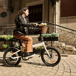 Mujer pedaleando una Bicicleta Eléctrica Plegable ADO A20 AIR color crema por una calle - E-Mobility Chile, Las Condes