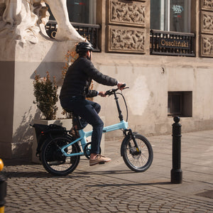 Ciclista recorriendo el casco histórico sobre una Bicicleta Eléctrica Plegable ADO A20 Ultra - E-Mobility Chile, Las Condes