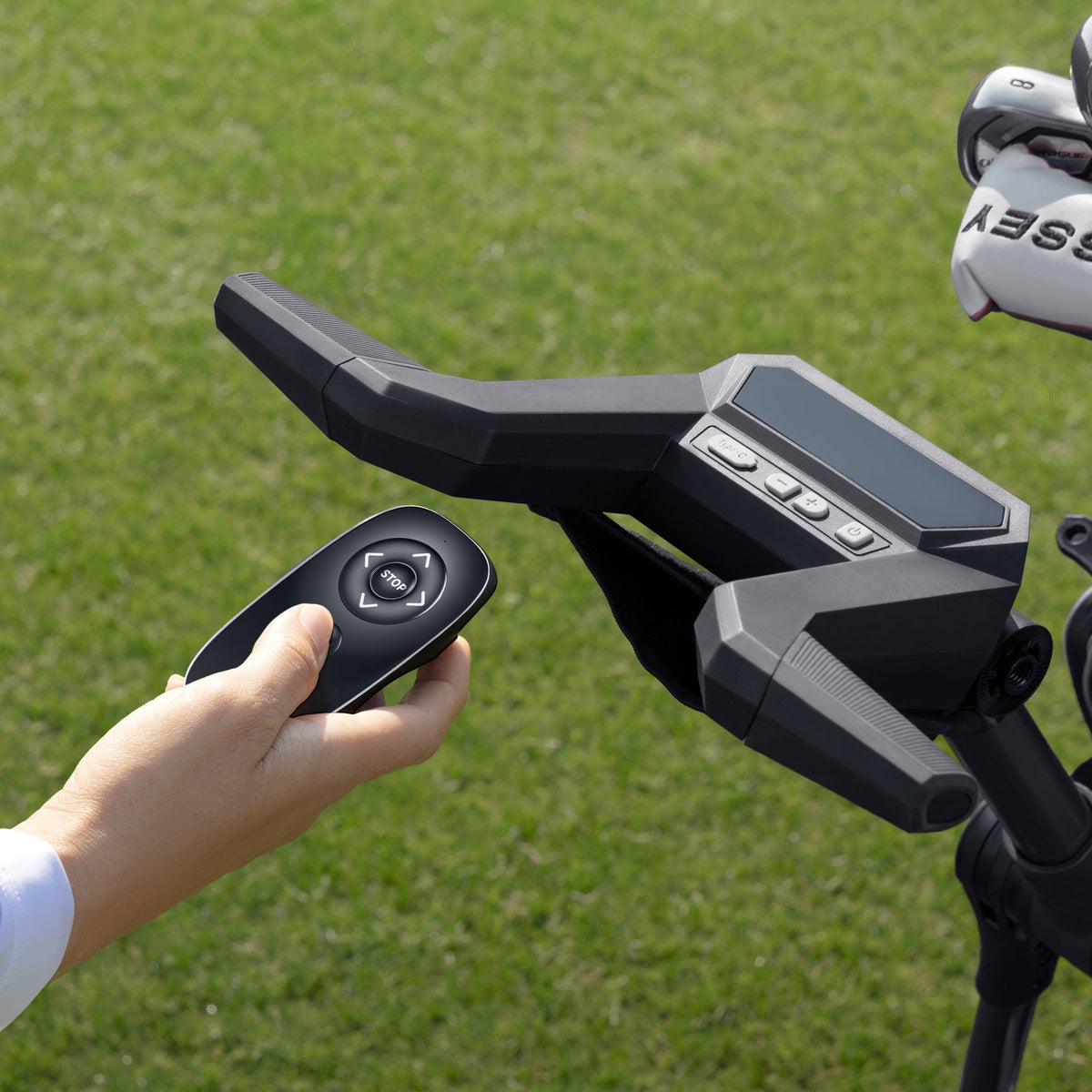 Control remoto del carro de golf eléctrico NAVEE Birdie 3 en la mano, junto al manubrio - E-Mobility Chile