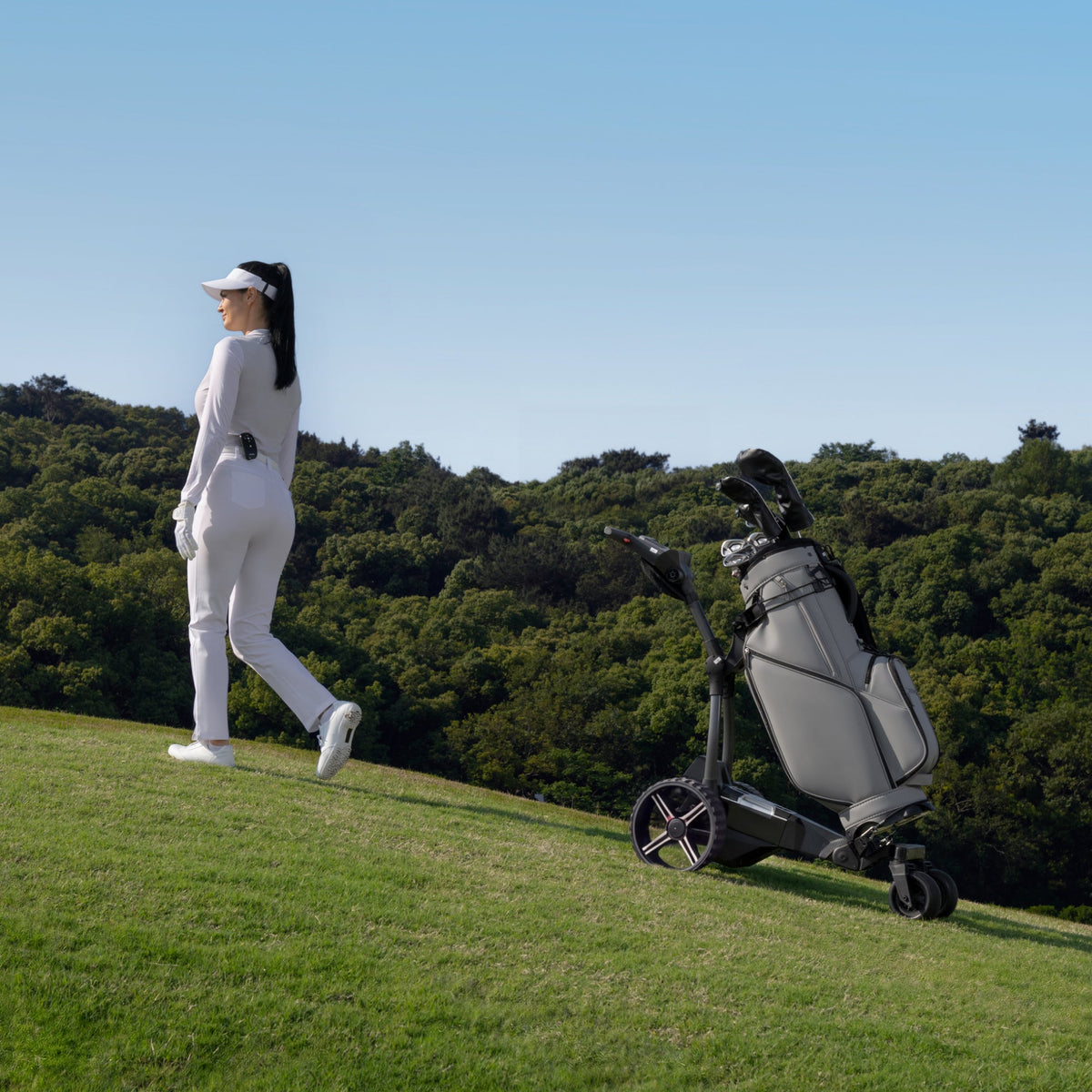 El carro de golf eléctrico NAVEE Birdie 3X sube solo la pendiente detrás de la golfista - E-Mobility Chile