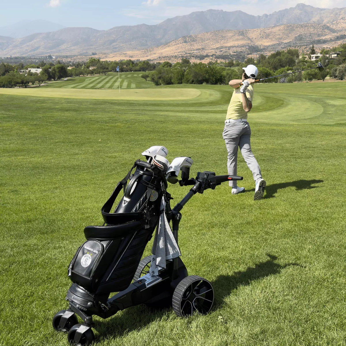 Carro de golf eléctrico NAVEE Birdie 3 con bolso, junto a un golfista en la cancha - E-Mobility Chile, Las Condes
