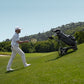Golfista maneja a distancia el carro de golf eléctrico NAVEE Birdie 3 mientras camina por la cancha - E-Mobility Chile