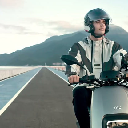 Persona conduciendo una Moto Eléctrica NIU Gova 03 por la costa - E-Mobility Chile, Las Condes