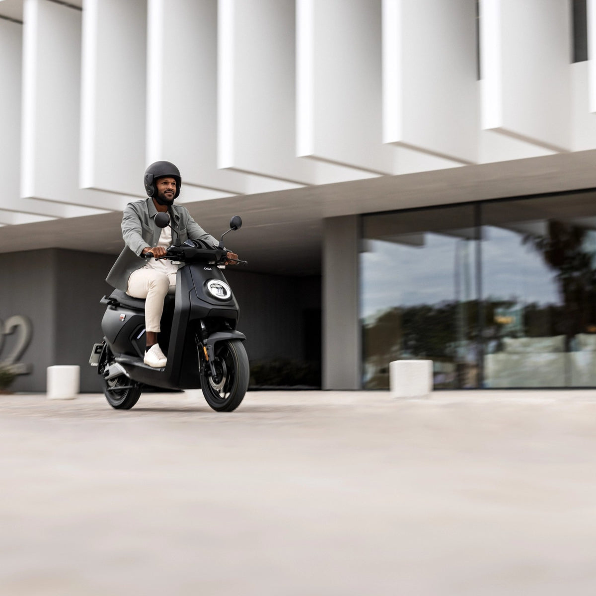 Persona conduciendo una Moto Eléctrica NIU MQi GT por la ciudad - E-Mobility Chile, Las Condes