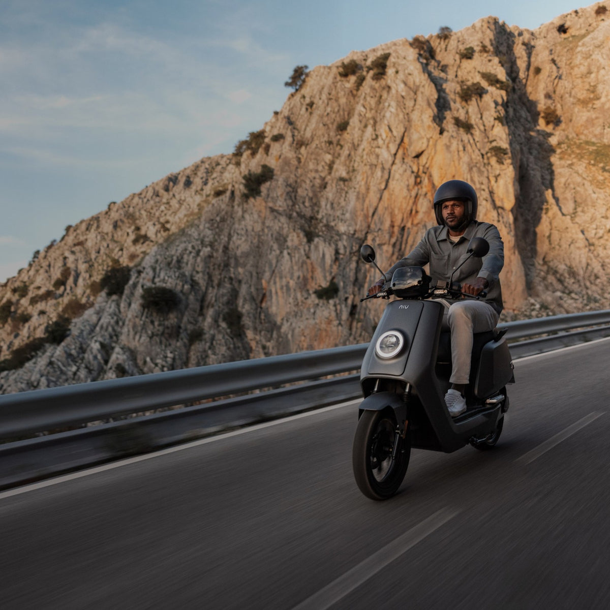 Motociclista en carretera de montaña sobre una Moto Eléctrica NIU NQi GTS Sport - E-Mobility Chile, Las Condes