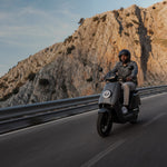 Motociclista en carretera de montaña sobre una Moto Eléctrica NIU NQi GTS Sport - E-Mobility Chile, Las Condes