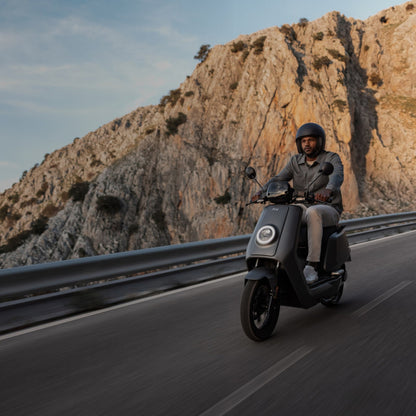 Motociclista en carretera de montaña sobre una Moto Eléctrica NIU NQi GTS Sport - E-Mobility Chile, Las Condes